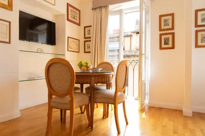 a dining room with a wooden table and chairs at Babuino 79 in Rome