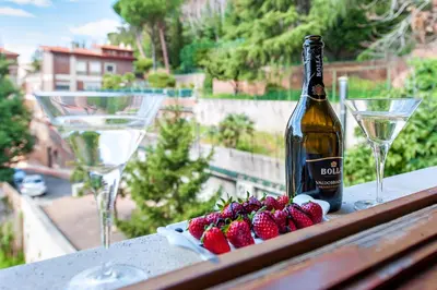a bottle of wine and two glasses on a table with strawberries at L'Oasi Verde a San Pietro apartment in Rome