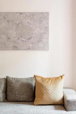 a painting hangs above a couch in a living room at SuityRHome RioneMonti56 in Rome