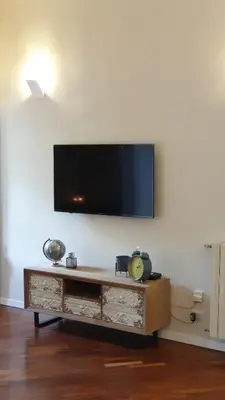 a living room with a tv on a wall at SuityRHome RioneMonti56 in Rome