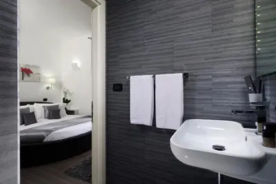 a bathroom with a sink and a bed at Gregorio VII Luxury Suites in Rome