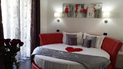 a bedroom with a bed with red roses on it at Gregorio VII Luxury Suites in Rome