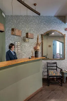 a woman standing behind a counter in a hair salon at Boutique Hotel Galatea in Rome