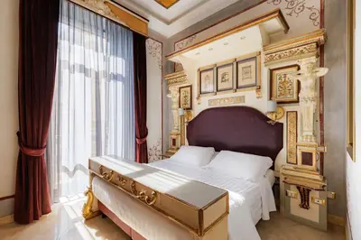 a bedroom with a king sized bed with a gold frame at Romanico Palace Luxury Hotel & SPA in Rome
