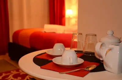 a table with two cups and saucers on it with a bed at Vatican Dream in Rome