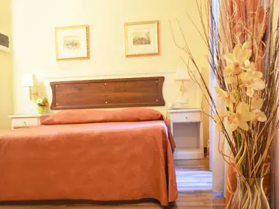 a bedroom with a bed with an orange blanket at Residenza Domiziano in Rome