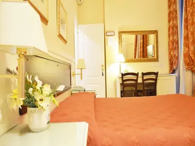 a hotel room with a bed and a vase of flowers at Residenza Domiziano in Rome