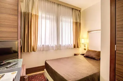 a hotel room with a bed and a window at The Strand Hotel in Rome