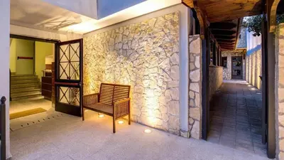 a hallway with a chair and a stone wall at The Strand Hotel in Rome
