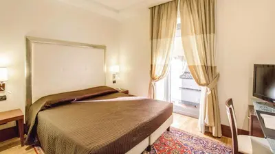 a hotel room with a bed and a television at The Strand Hotel in Rome
