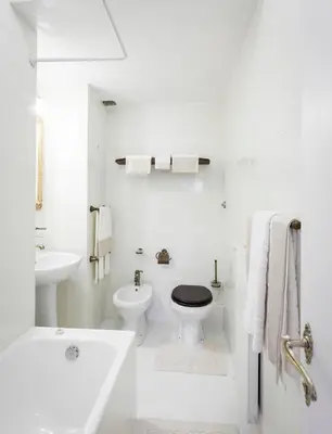 a white bathroom with a toilet and a sink at Suite Sarandrea in Rome