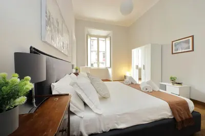 a bedroom with a large bed with white sheets and pillows at 4BNB - Spacious Belli Apartment in Rome