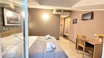 a room with a bed and a table and a desk at Hotel Concorde in Rome