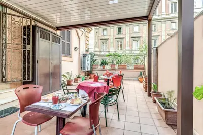 an outdoor patio with tables and chairs on a balcony at Hotel Milo in Rome