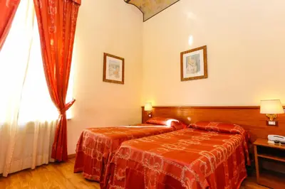 a hotel room with two beds and a window at Hotel Tempio Di Pallade in Rome