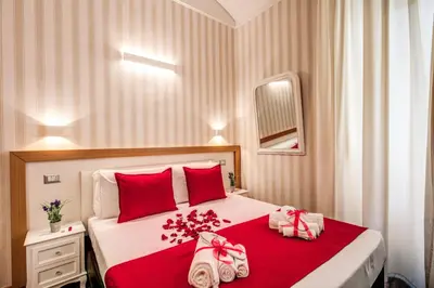 a bedroom with a red and white bed with red pillows at Auditorium Mecenate in Rome