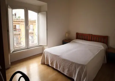 a bedroom with a bed and a large window at Tourist House B&B in Rome