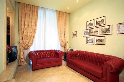 a living room with two red couches and a window at Hotel Dina in Rome