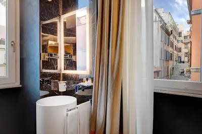 a bathroom with a white toilet and a window at Dharma Boutique Hotel & SPA in Rome