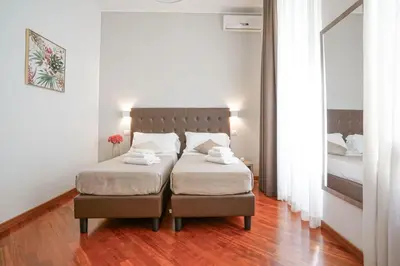 a bedroom with two beds and a mirror at Hotel St. Moritz in Rome