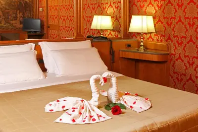 two swans sitting on a bed in a hotel room at Hotel Arcangelo in Rome