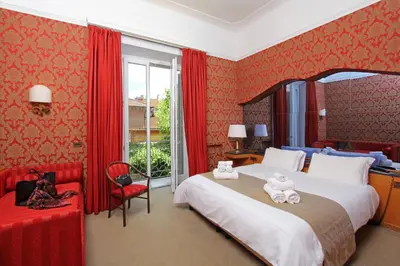 a bedroom with a large bed with red walls at Hotel Arcangelo in Rome