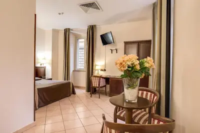 a hotel room with a table with a vase of flowers on it at Hotel San Marco in Rome