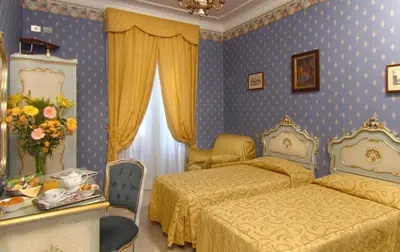 a bedroom with two beds and a table and chairs at Hotel Villa San Lorenzo Maria in Rome