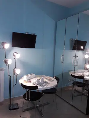 a room with two tables with lights and a blue wall at B&B Anni 50 in Rome