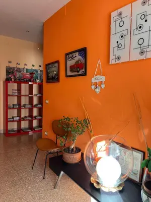 a room with an orange wall with a table and a chair at B&B Anni 50 in Rome