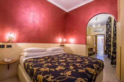 a bedroom with a bed and a red wall at Hotel Fellini a Fontana di Trevi in Rome