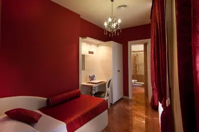 a red bedroom with a bed and a desk at Hotel Fellini a Fontana di Trevi in Rome
