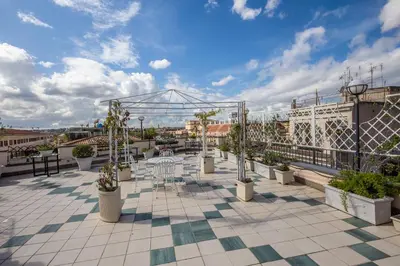 a patio with tables and trees on a roof at Hotel Fellini a Fontana di Trevi in Rome