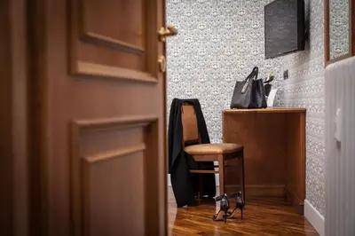 a chair sitting next to a desk with a purse at Suite Beccaria A Piazza Del Popolo in Rome