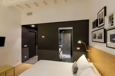 a bedroom with a white bed and a black wall at Coronari Palace in Rome