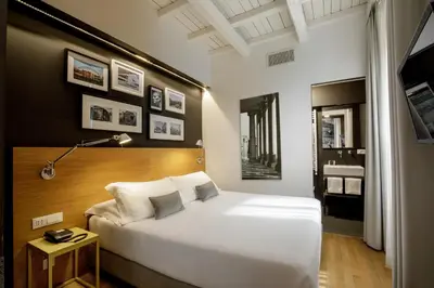 a bedroom with a large white bed and a bathroom at Coronari Palace in Rome