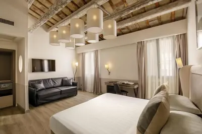 a hotel room with a bed and a couch at Condotti Palace in Rome