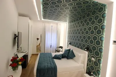 a bedroom with a bed with a green patterned wall at Albergo Abruzzi in Rome