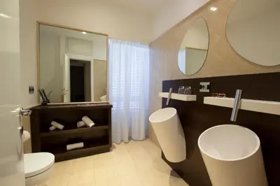 a bathroom with a toilet and a sink and a mirror at SuiteSistina for Brave Lovers in Rome