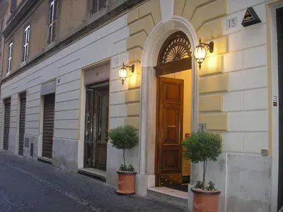 a building with a door and potted plants on a street at Hotel Artorius in Rome