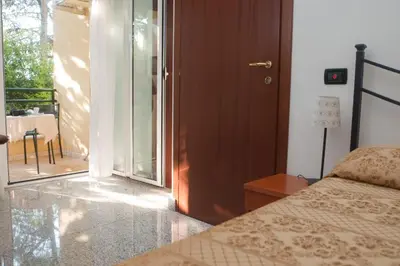 a bedroom with a bed and a door to a balcony at Hotel Antico Acquedotto in Rome