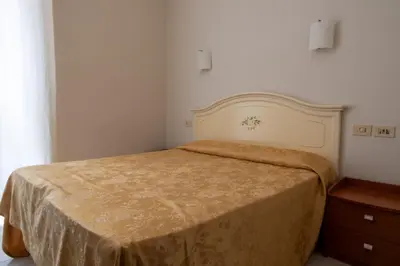 a bedroom with a bed and a wooden dresser at Hotel Ventura in Rome