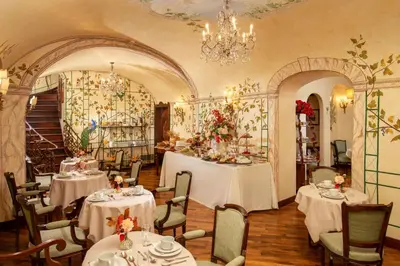 a restaurant with white tables and chairs and a chandelier at Boutique Hotel Campo de' Fiori in Rome