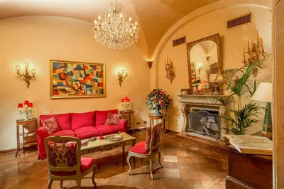a living room with a red couch and a fireplace at Boutique Hotel Campo de' Fiori in Rome
