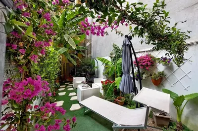 an outdoor patio with flowers and an umbrella at Luxury Domus in Rome