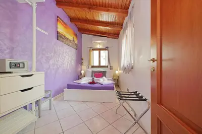 a bedroom with purple walls and a bed with a chair at Luxury Domus in Rome