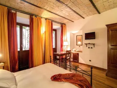 a bedroom with a bed and a desk in a room at Residenza Domizia in Rome
