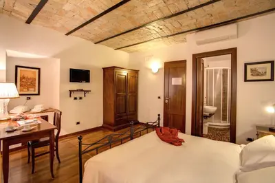 a bedroom with a bed and a desk and a sink at Residenza Domizia in Rome