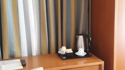 a table with a lamp and two cups on it at Crosti Hotel in Rome