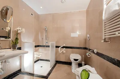 a bathroom with a tub and a sink and a toilet at Cardinal Hotel St. Peter in Rome